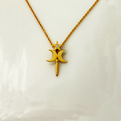 A gold-colored pendant featuring a star-shaped design with a natural brilliant diamond in the center, displayed against a white background.