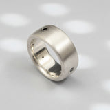 A matte-finished white gold ring with three natural black diamonds set in a row.